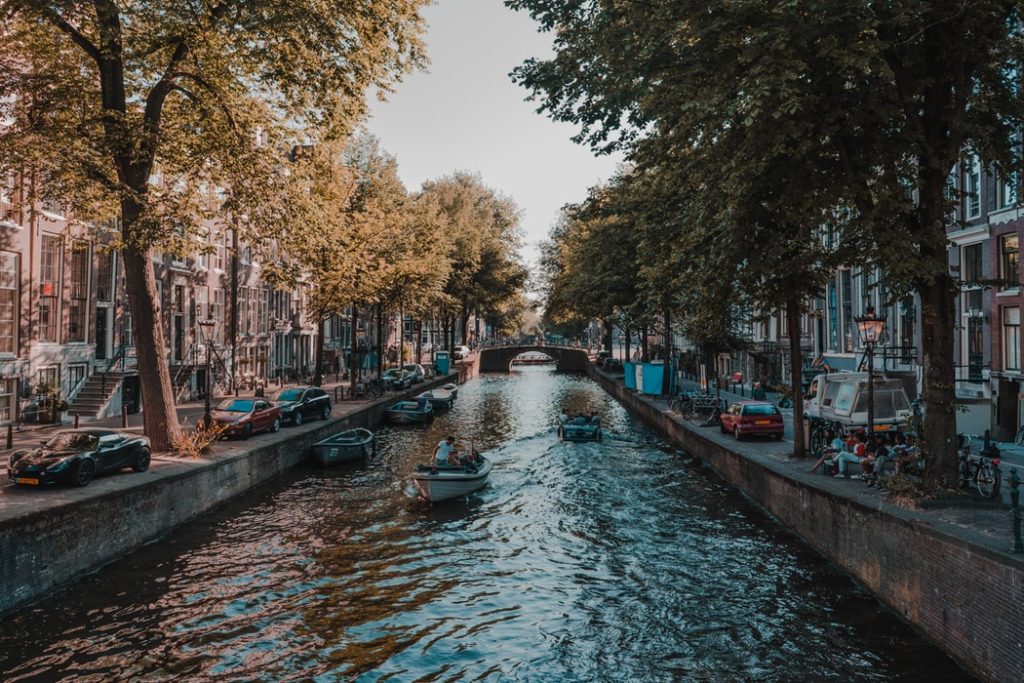 Top 10 most Popular blog posts of 2019 featured by top US travel hacker, Points with Q: image of Amsterdam Netherlands Boats Canal
