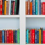 assorted-title book lot placed on white wooden shelf