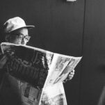 man in black shirt reading newspaper