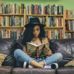 woman reading a book while sitting on black leather 3-seat couch