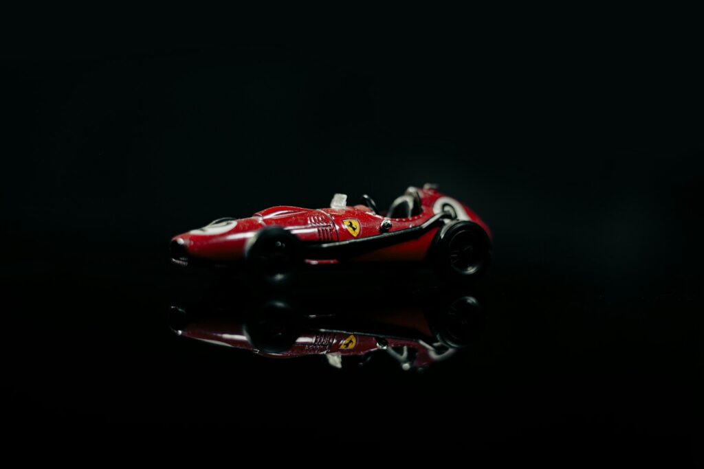 Bernie Ecclestone business lessons A red race car on a black background
