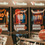 Relentless Improvement Basketballs displayed in front of framed sports jerseys.