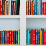 august reading list assorted-title book lot placed on white wooden shelf